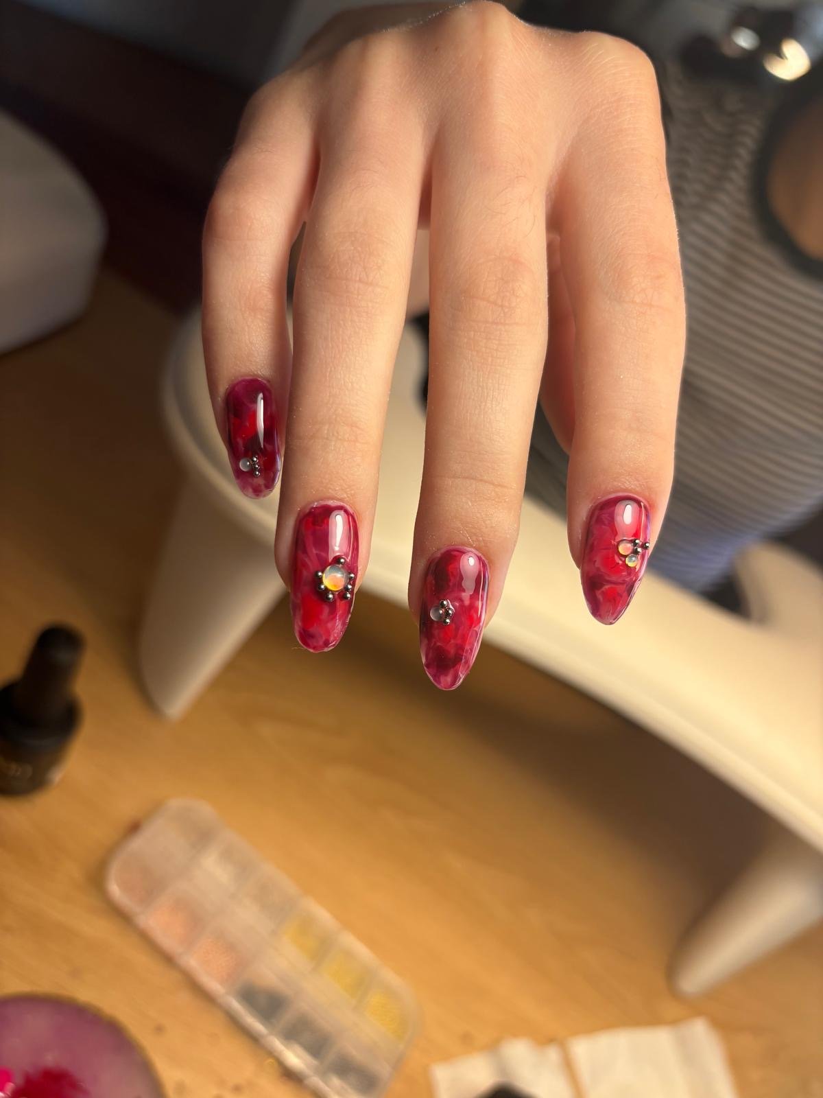 Russian manicure hard gel and colour in red marble stiletto with nail extensions and crystal accents by Queen Bee Nails in Rockingham WA